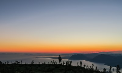 男子站在山上的剪影照片